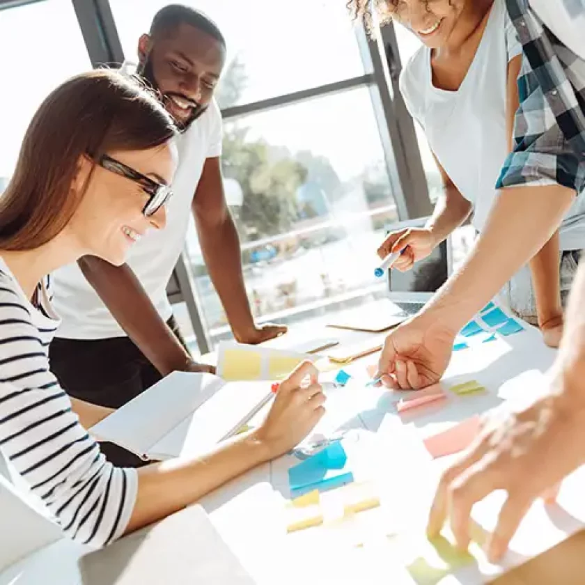 Groupe de collaborateurs échangeant lors d'un atelier en présentiel dans une ambiance conviviale